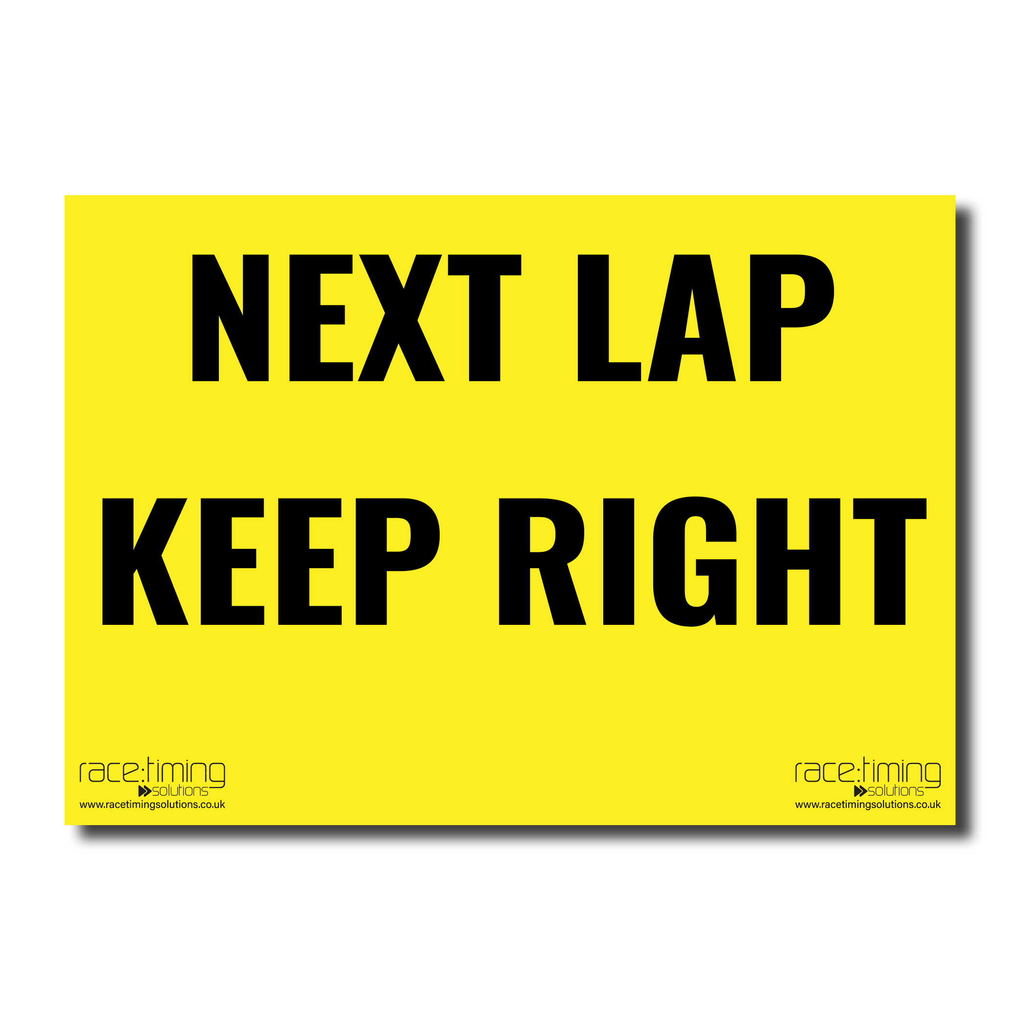 Yellow sign with black text 'NEXT LAP KEEP RIGHT'